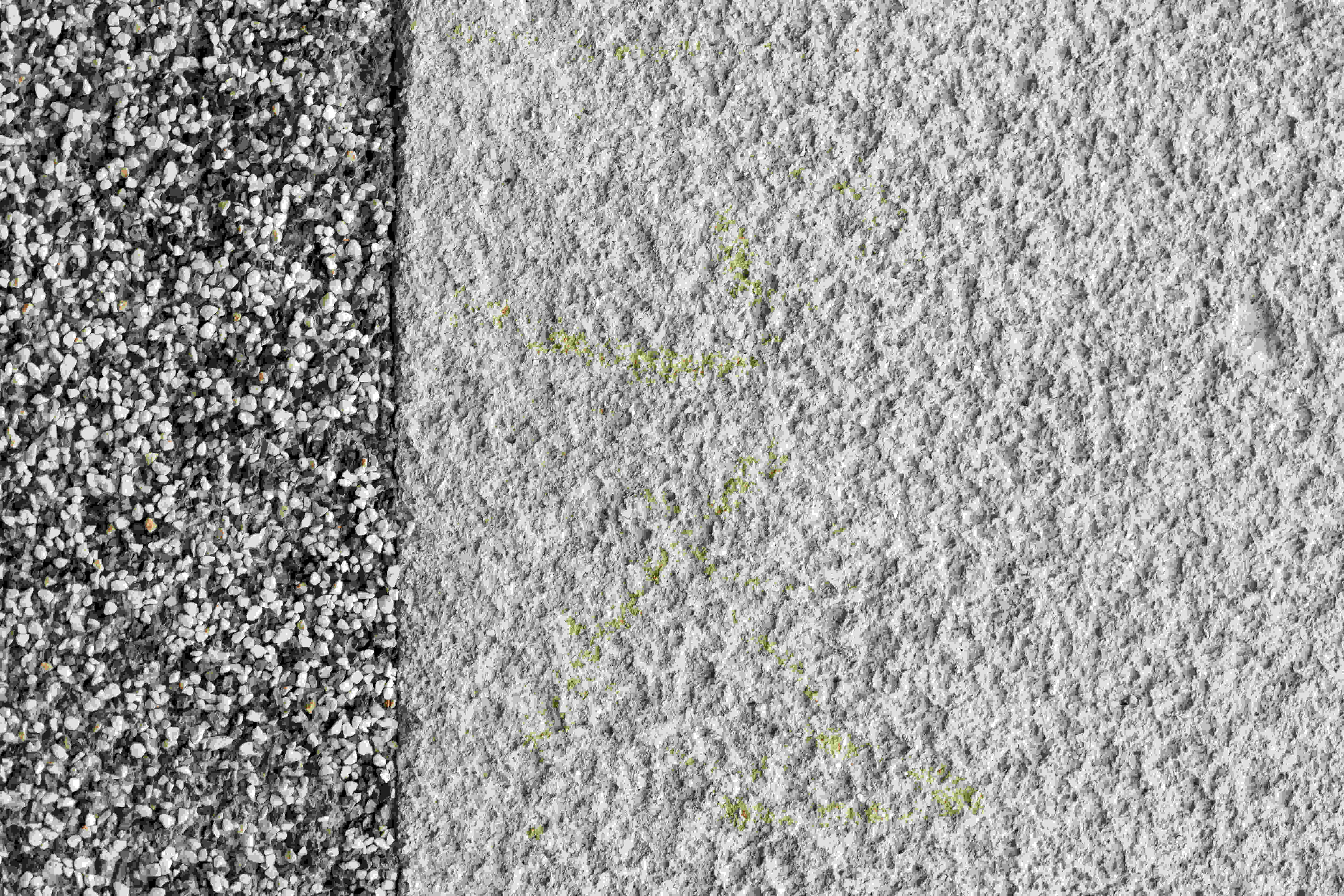 Nahaufnahme zweier Bodenoberflächen: links ein Steinteppich aus kleinen Kieselsteinen, rechts eine raue Putz- oder Betonfläche.